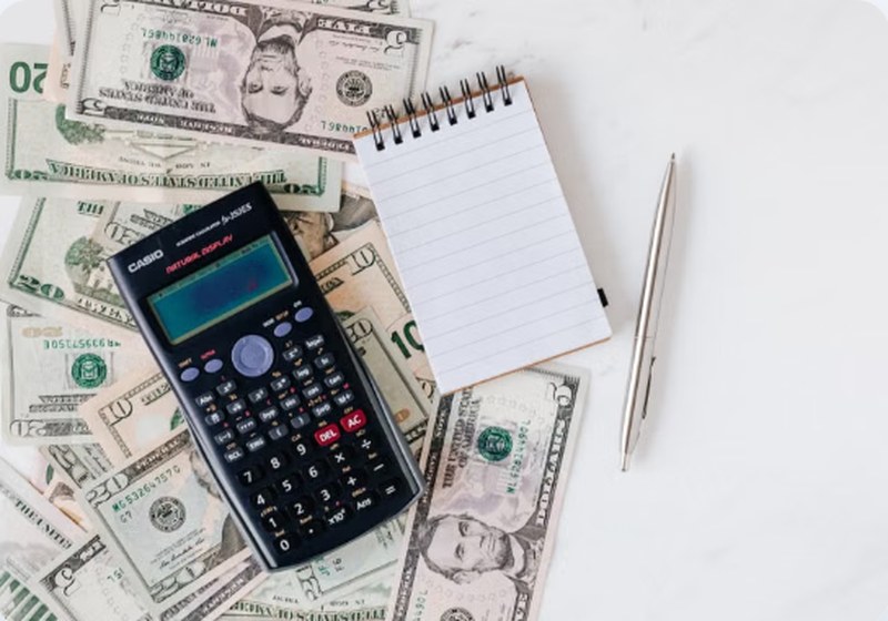 Calculator and cash on desk — Varo Believe secured card for credit building